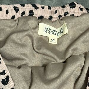 Listicle that is cream in color with black Polka dots , size is a Large